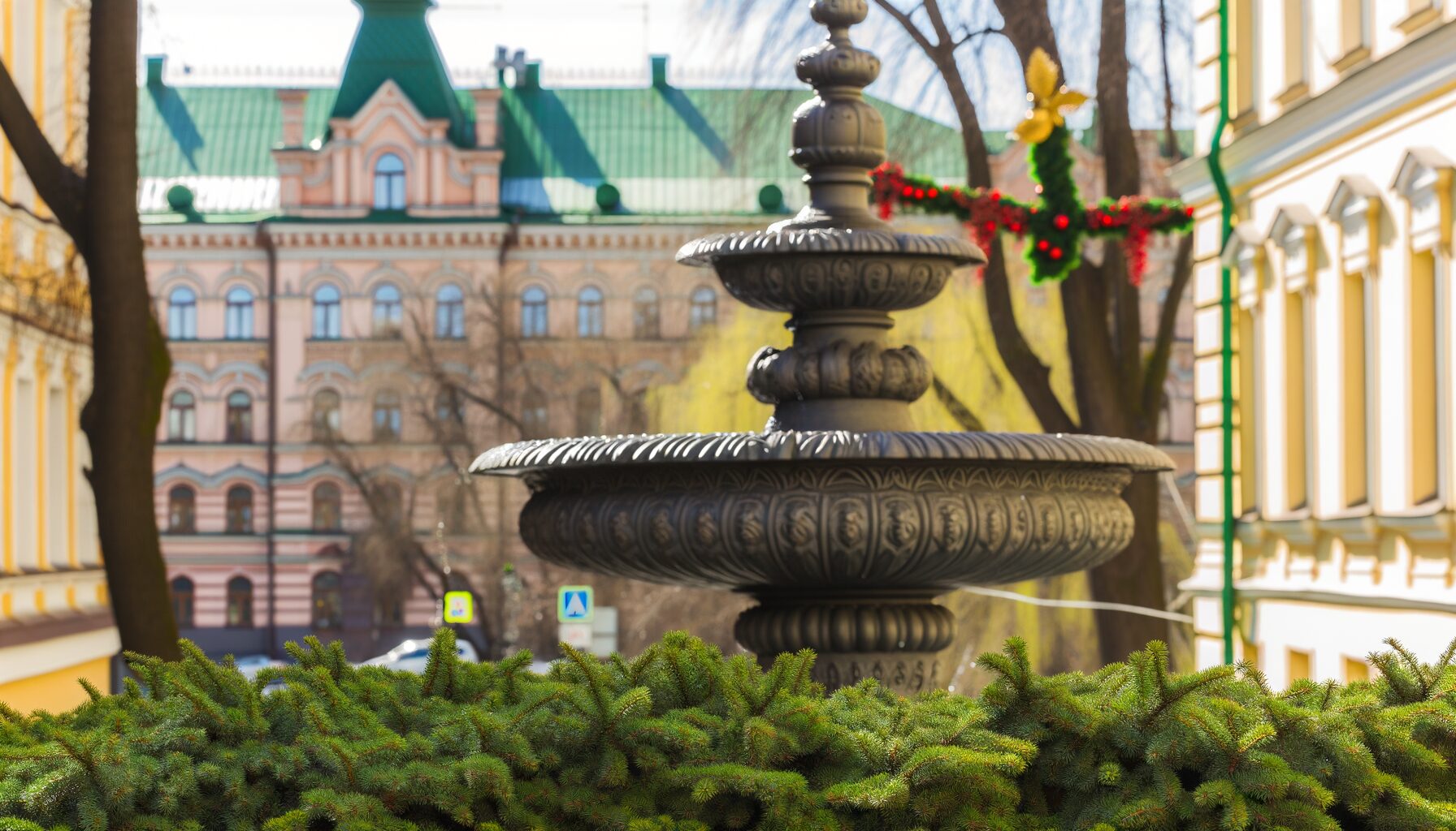 Der Glasbrunnen an der St. Petersburger Straße im Frühling umgeben von Grün